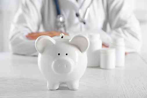 Arzt sitz hinter Sparschwein