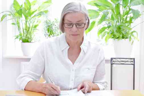 Ältere Dame bearbeitet Unterlagen